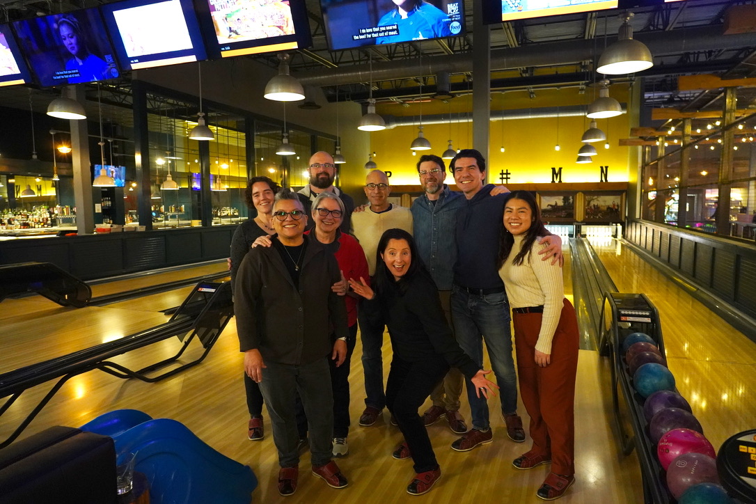 Group of people taking picture at a bowling place.